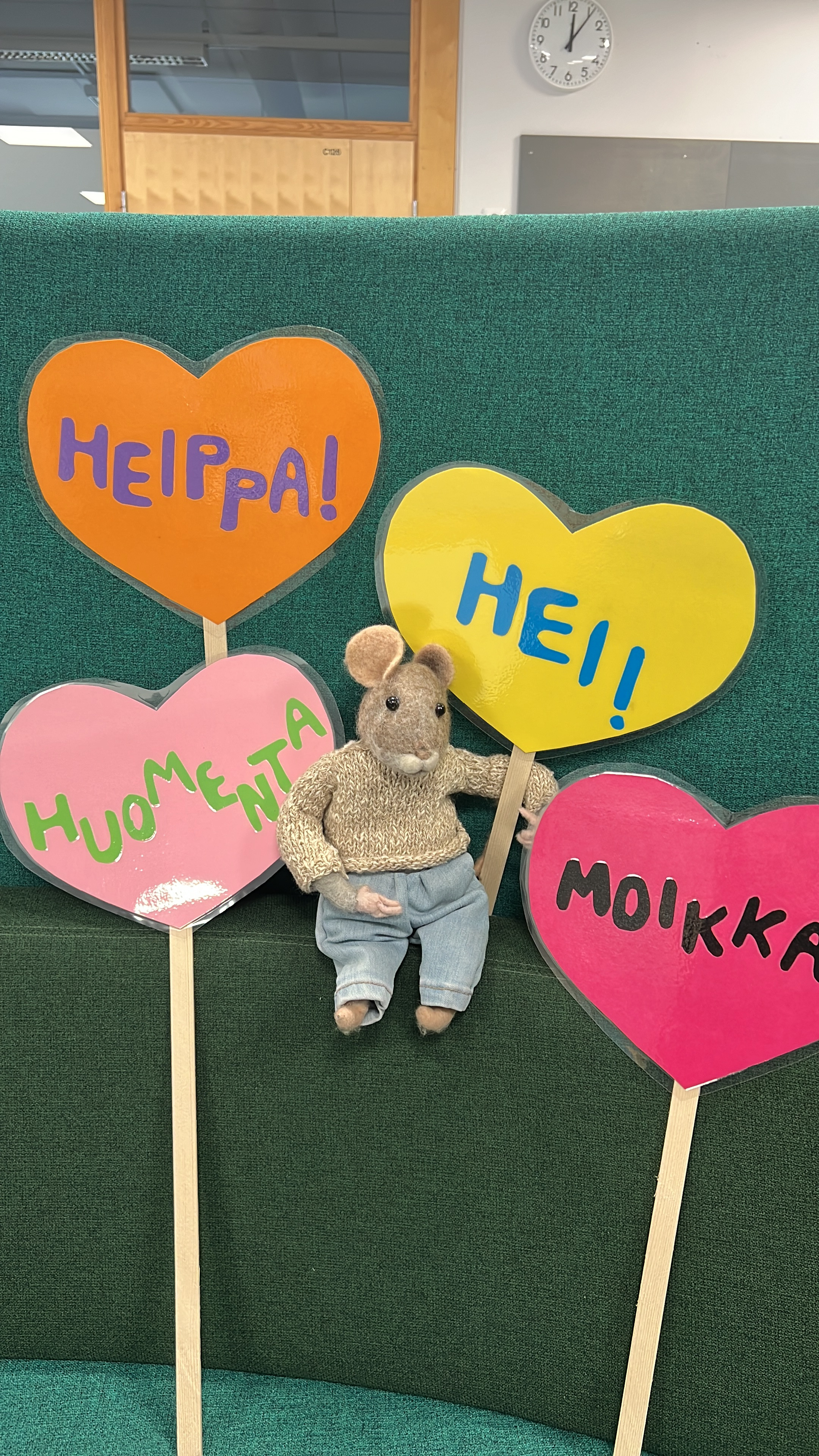 Koulun maskotti Hipsu-hiiri kuvassa tervehdyskylttien kanssa.