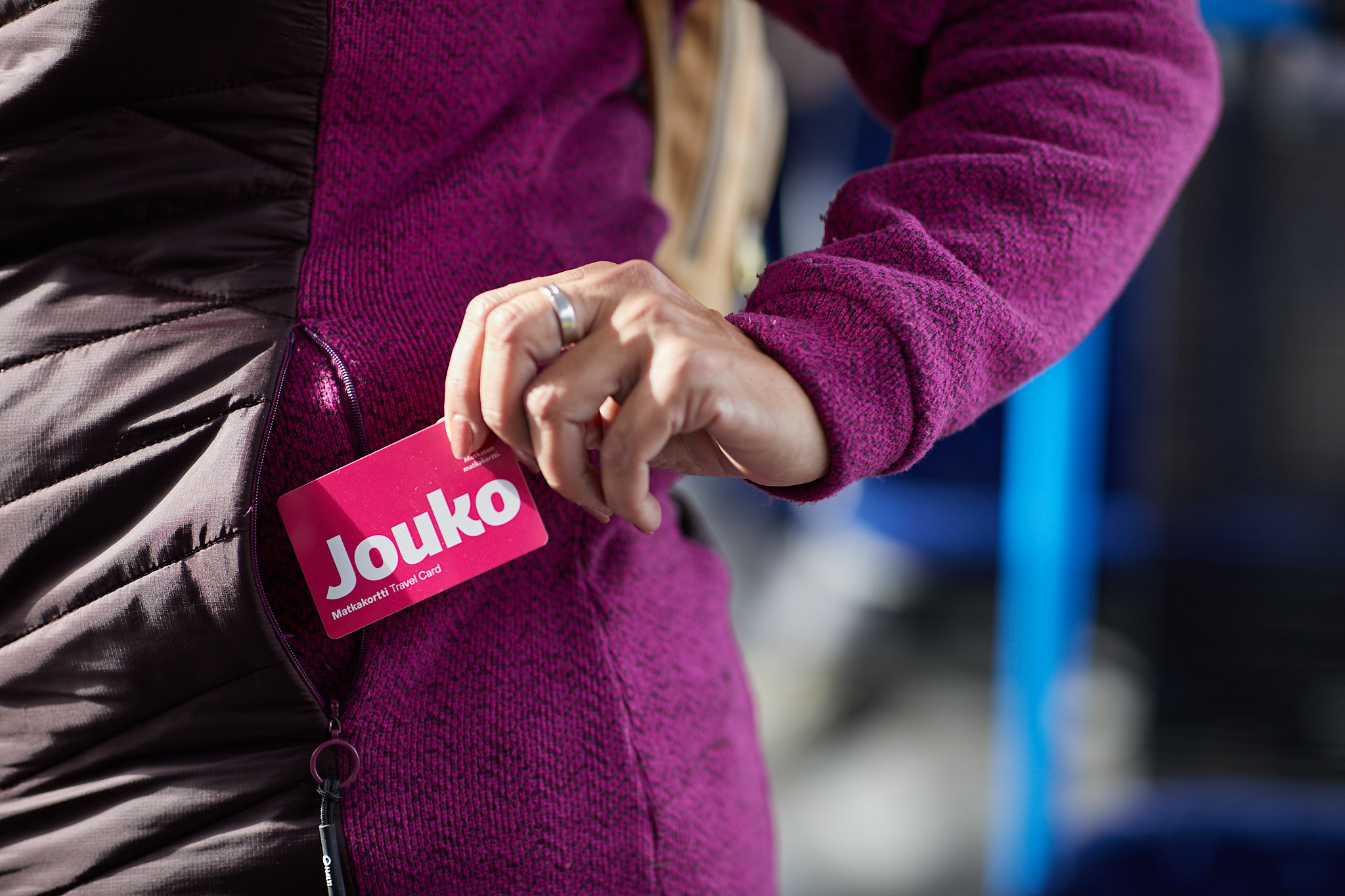 Henkilö ottamassa taskusta pinkkiä Jouko-bussikorttia.