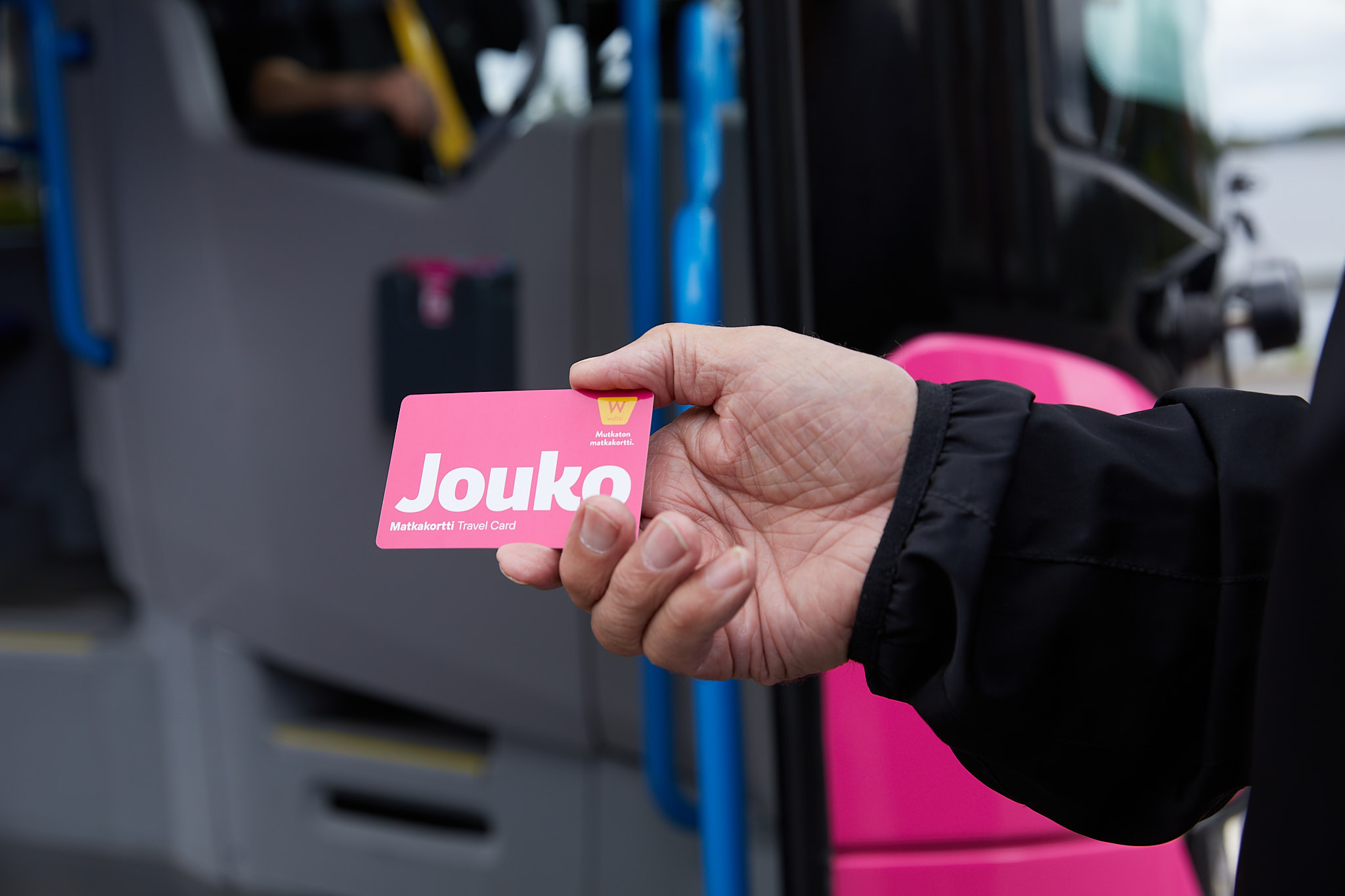 Person giving out a pink Jouko-buscard.