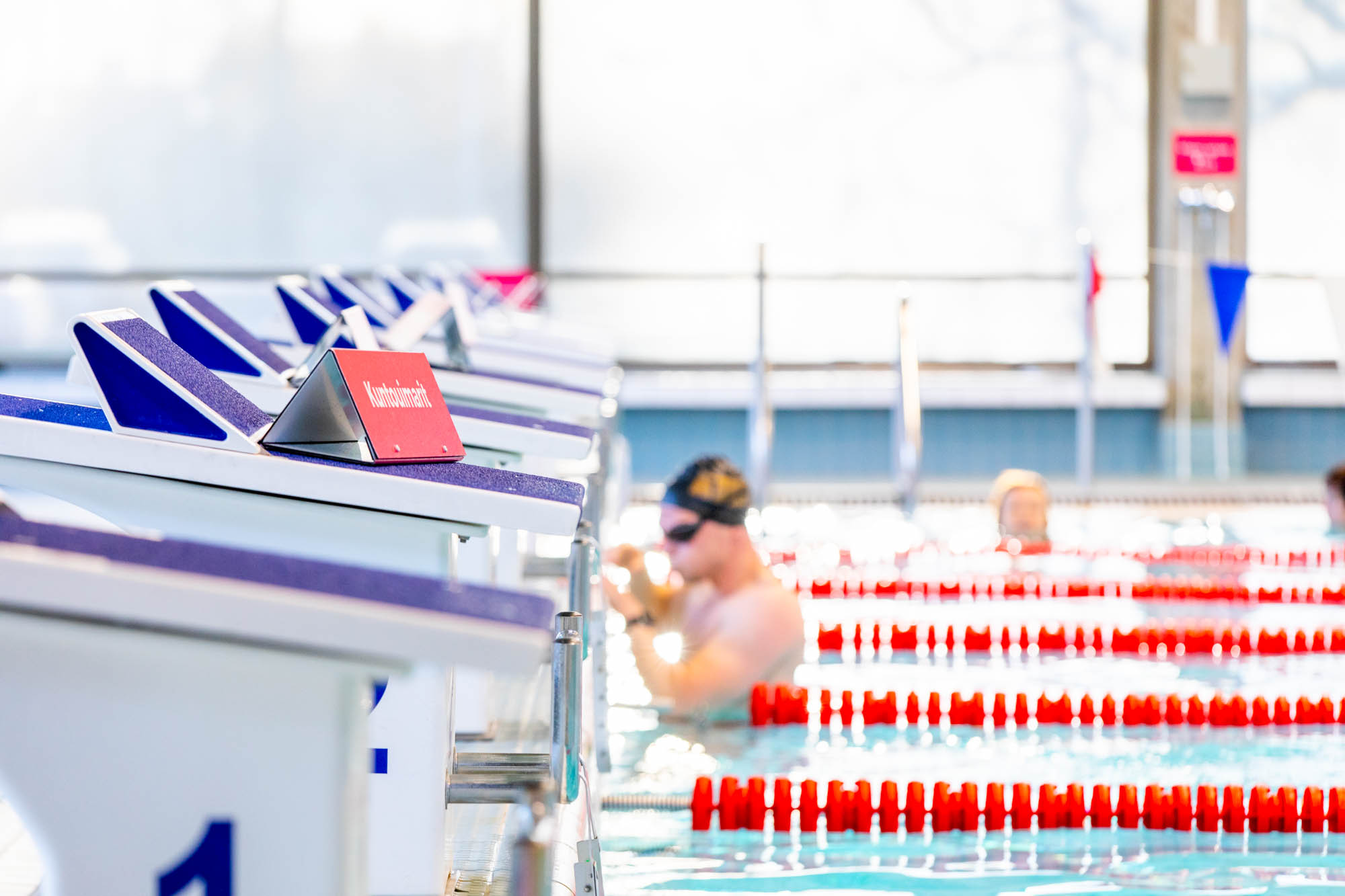Uimahallin allasta ja päätyä. Uimareita taustalla.