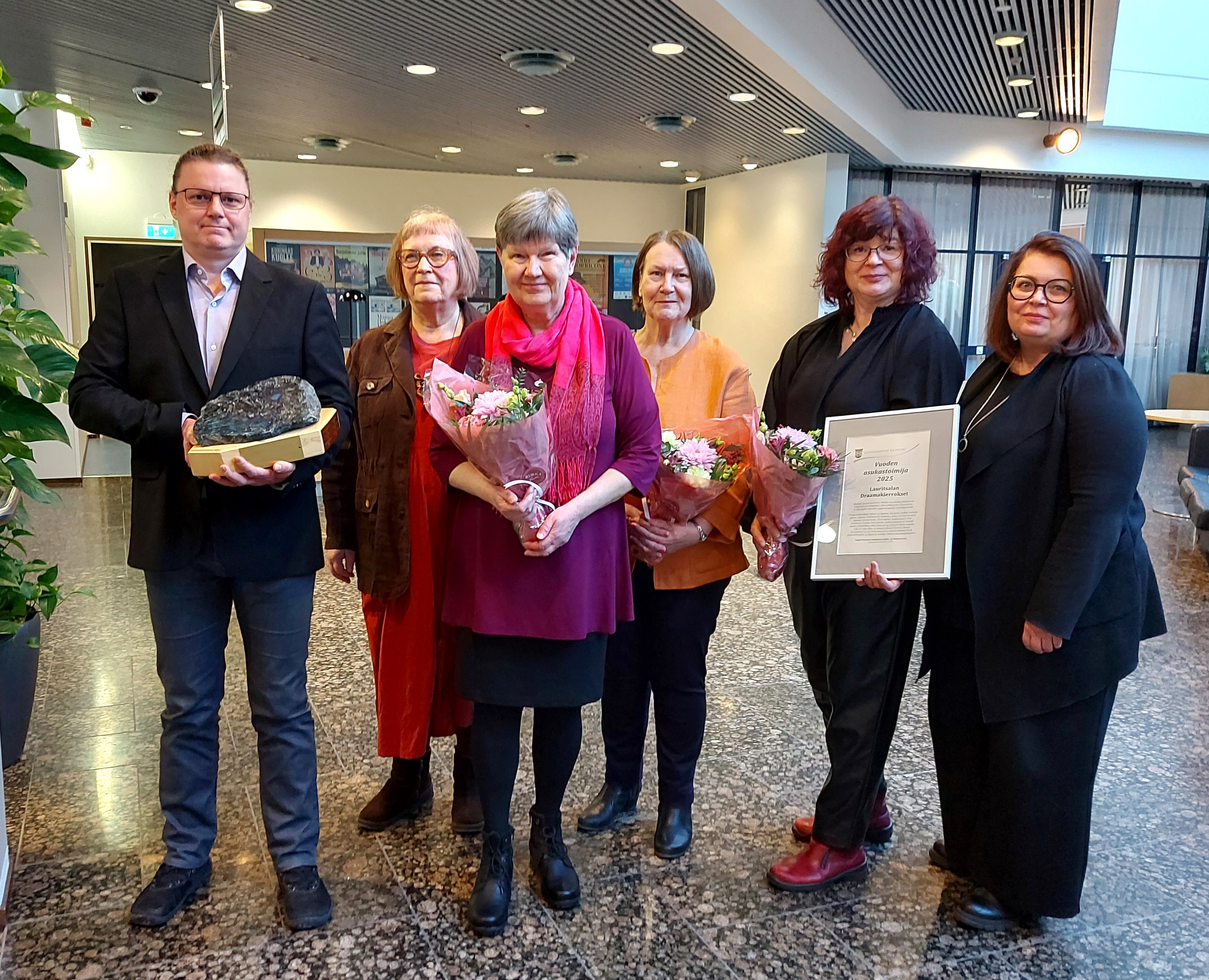 Kuusi henkilöä kunniakirjat kädessään.