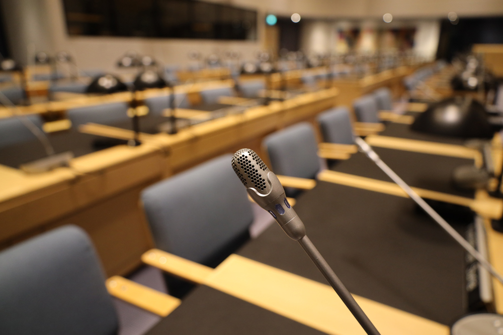 Mikrofoneja valtuustosalissa.