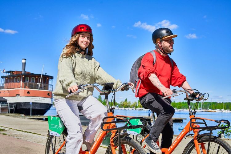 Kaksi pyöräilijää aurinkoisena päivänä.