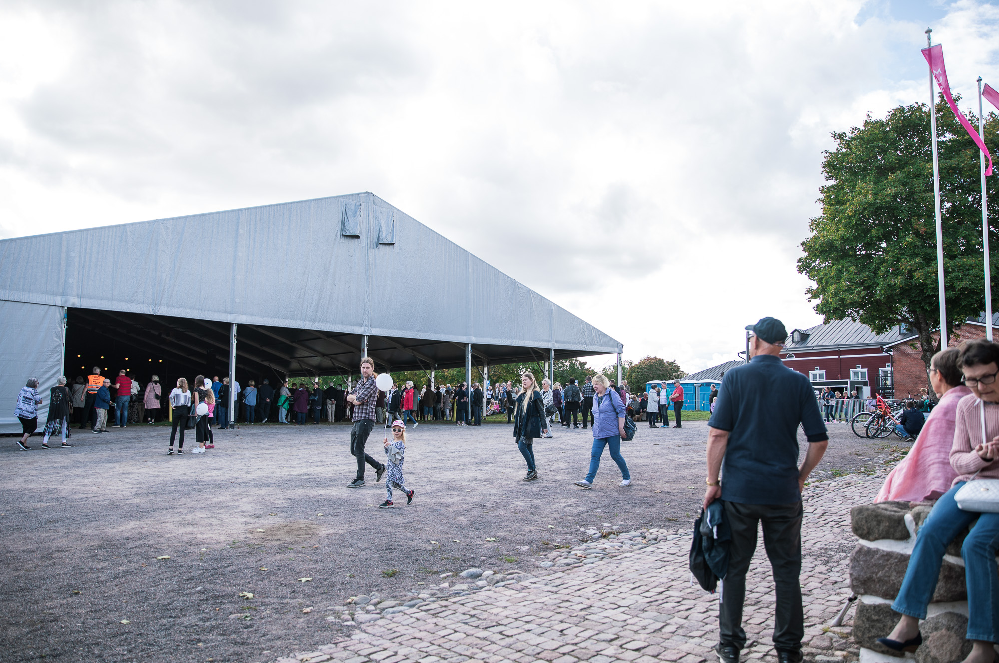 Ihmisiä tapahtumateltan ulkopuolella.