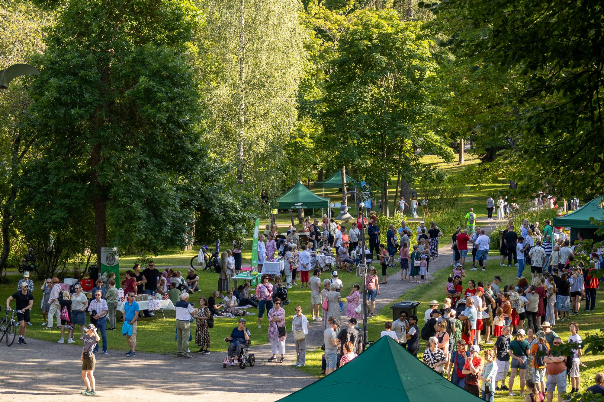 Pusupuistossa on paljon ihmisiä viettämässä kesäpäivää Mariannen nimppareiden merkeissä.