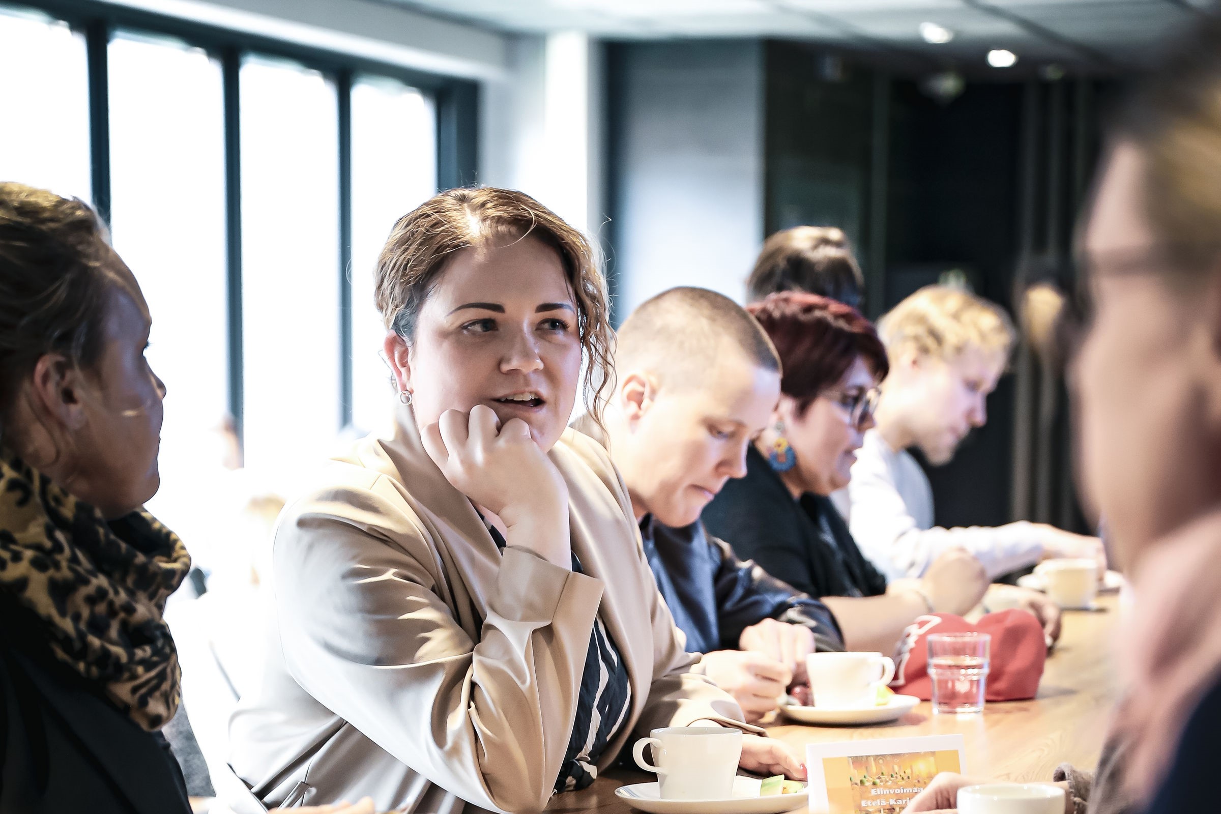 Ihmisiä keskustelemassa pöydän ääressä.