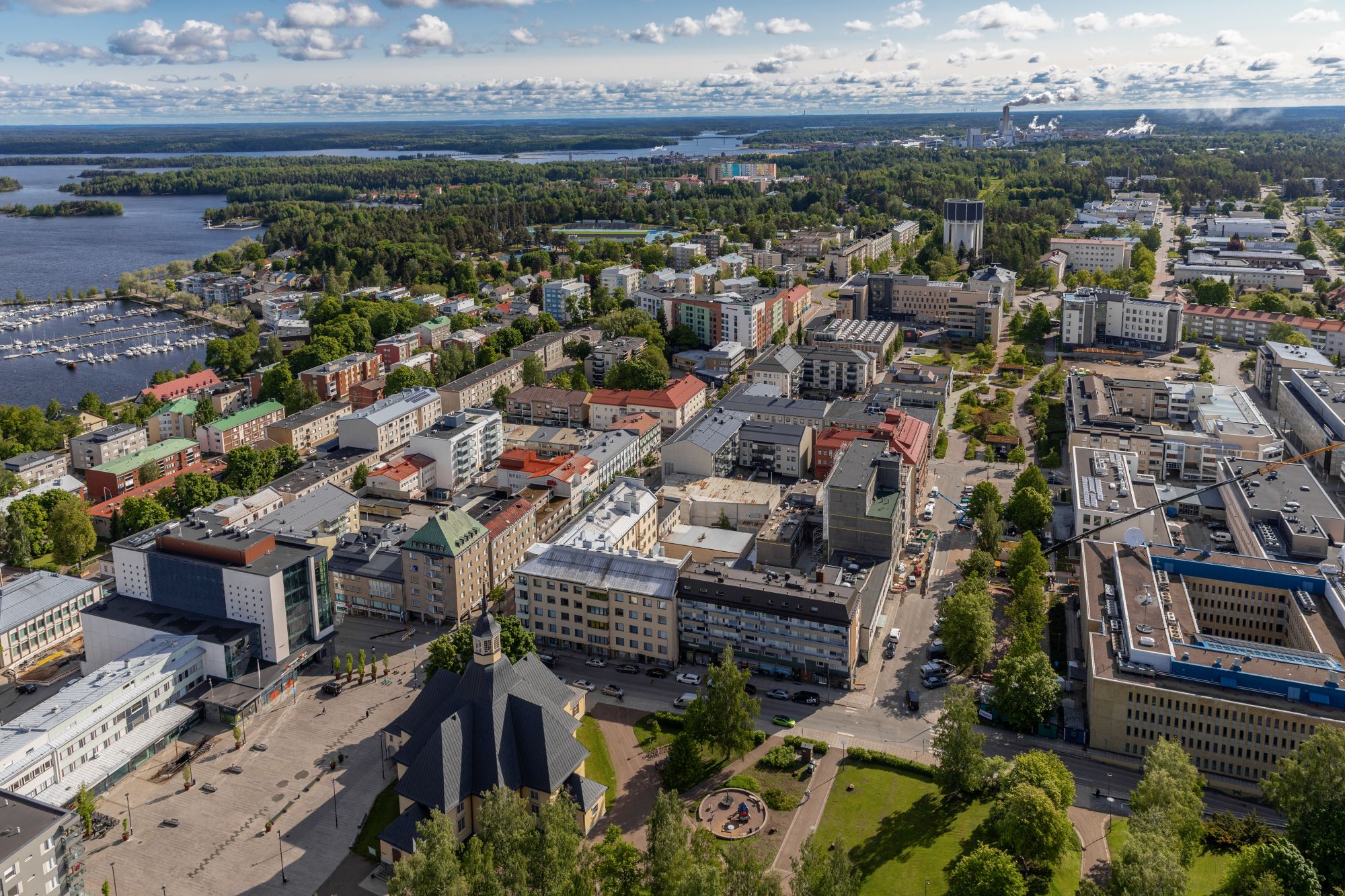 Ilmakuva Lappeenrannan keskustan rakennusten yllä, Saimaa näkyy kauempana.