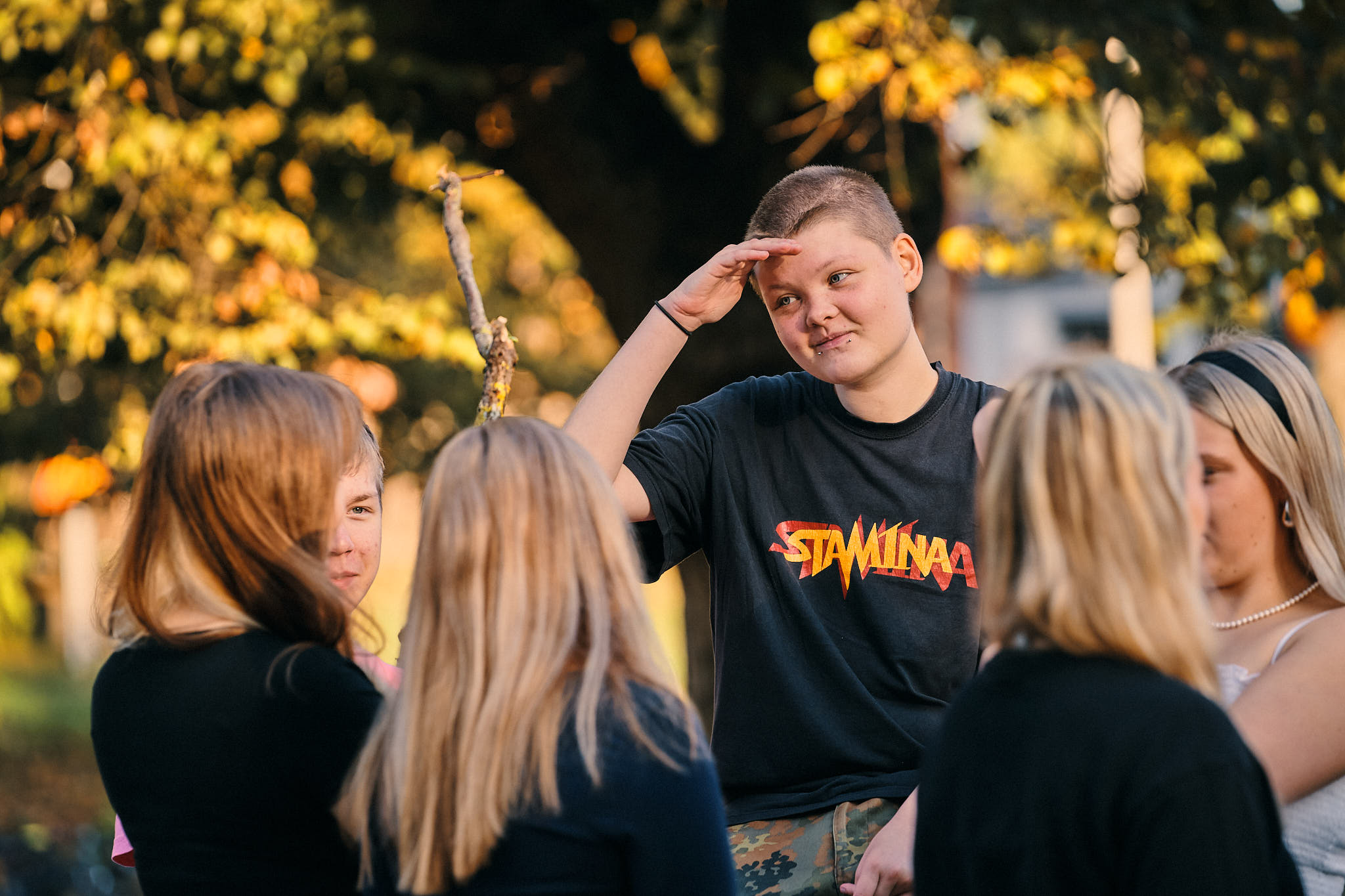 Kuusi nuorta toisiaan kohden aurinkoisessa puistossa.
