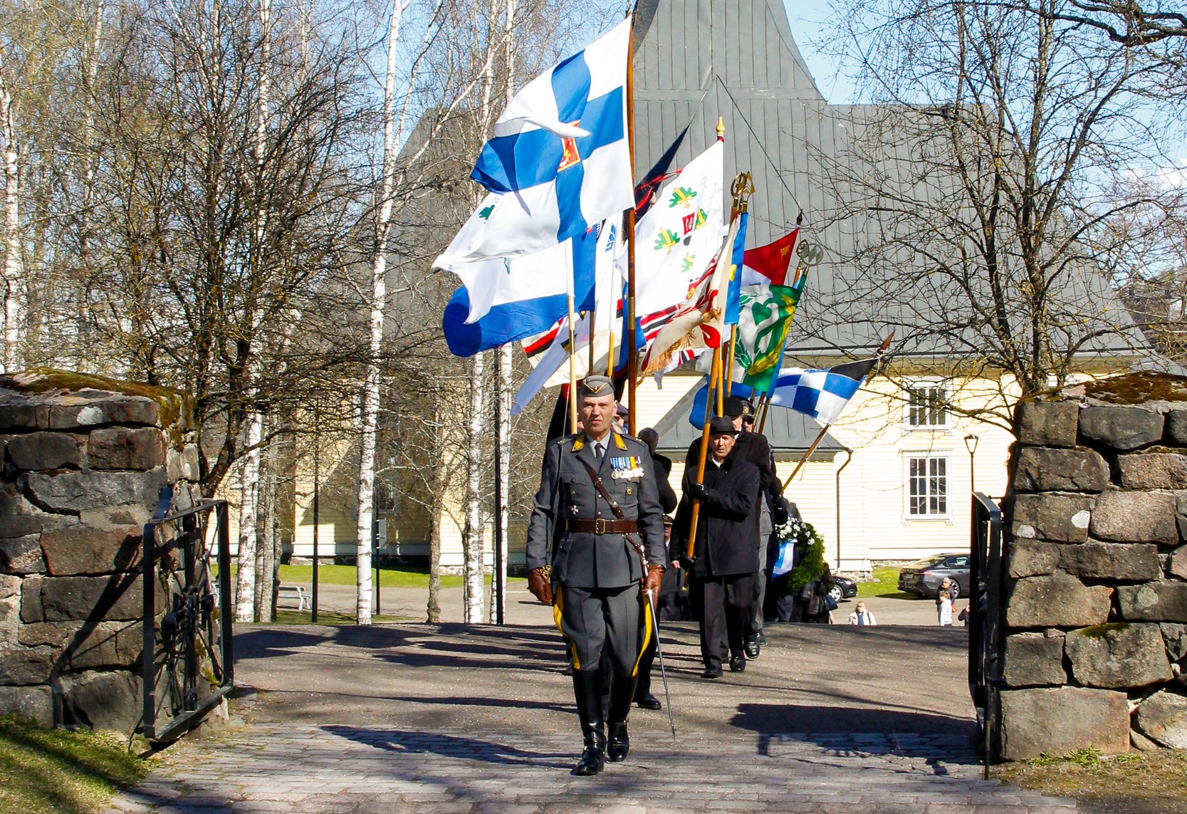 Lippulinna kulkemassa Lappeenrannan Reserviupseerikerhon perinneupseeri Fredrik Söderlundin johdolla sankarihautausmaan portista. 