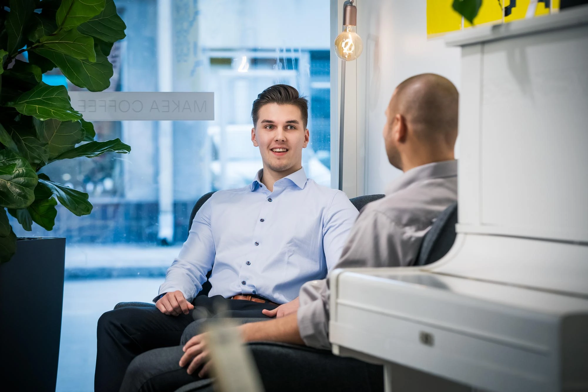 kaksi miestä keskustelee keskenään istuen